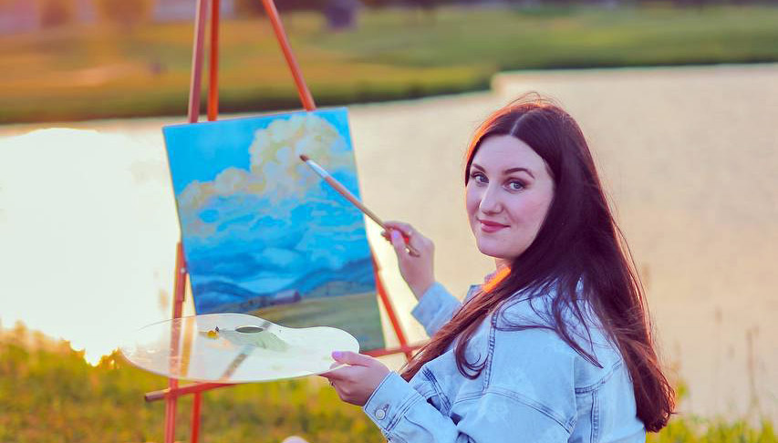 Yuliia working on a landscape painting